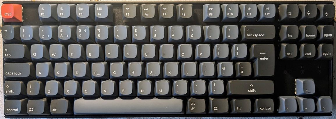 Photograph of the assembled Keychron K8 pro with the UK Windows key setup. The colours are predominantly a dark blue/grey.