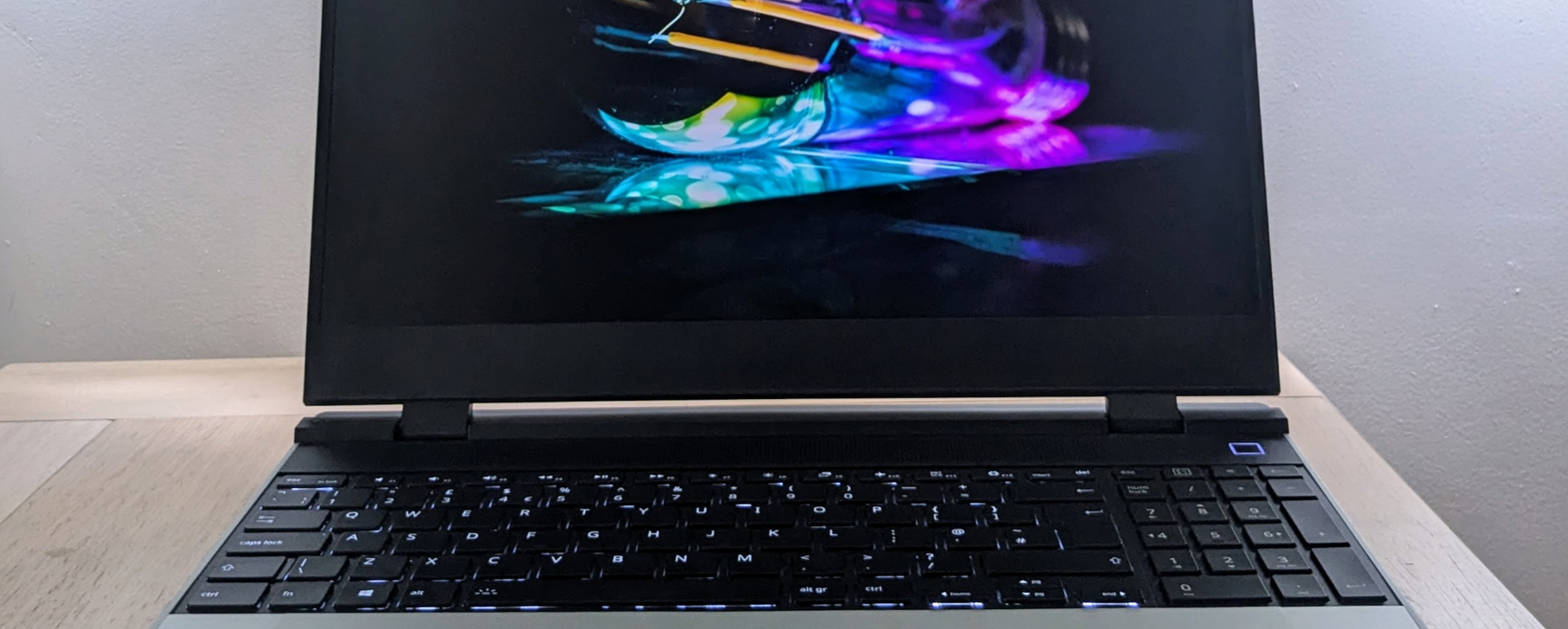 Cropped photo showing part of a laptop screen and part of its keyboard. The laptop is on.